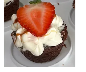 Cupcake topped with cream and a strawberry